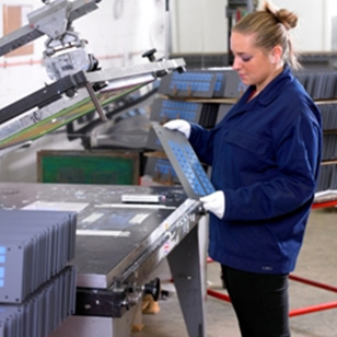 a woman operating a screen printing machine