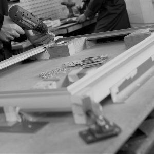 black and white image of a mans hands carrying out the assembly process