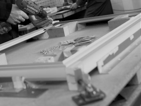 black and white image of a mans hands carrying out the assembly process