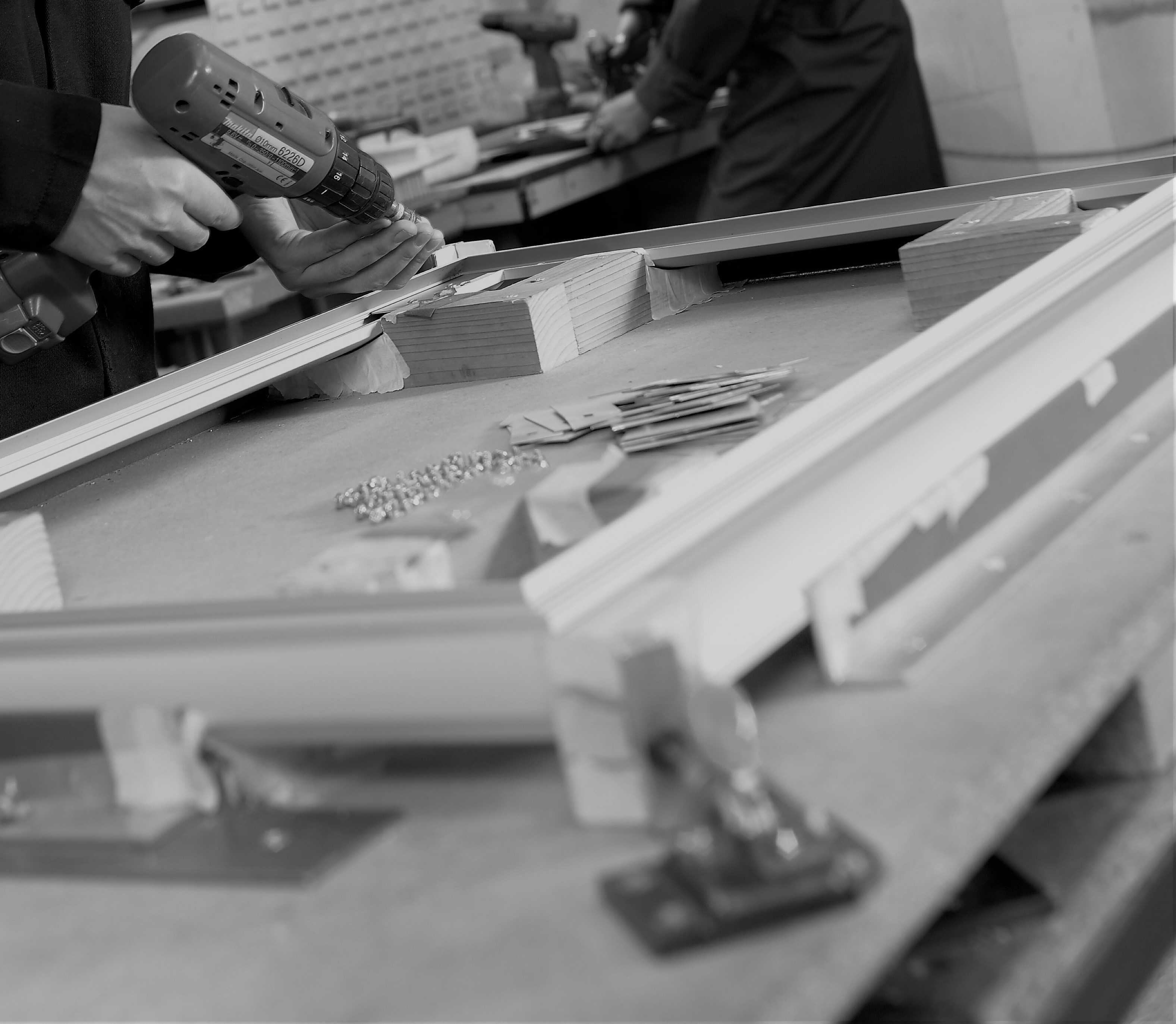 black and white image of a mans hands carrying out the assembly process