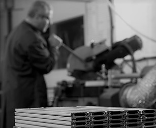 black and white capture of an older man operating a mitre saw