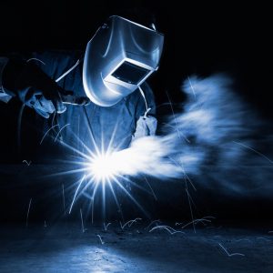welder with sparks surrounding them