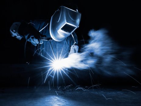 welder with sparks surrounding them