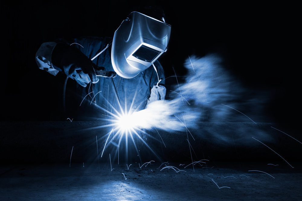 welder with sparks surrounding them